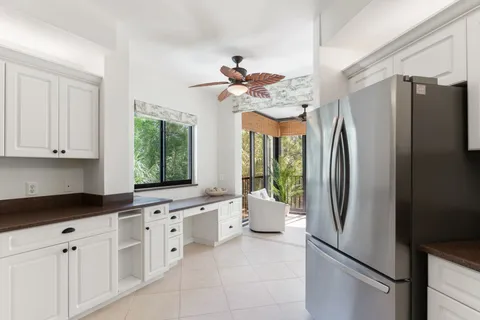 a kitchen with stainless steel appliances granite countertop a refrigerator a sink a stove and white cabinets