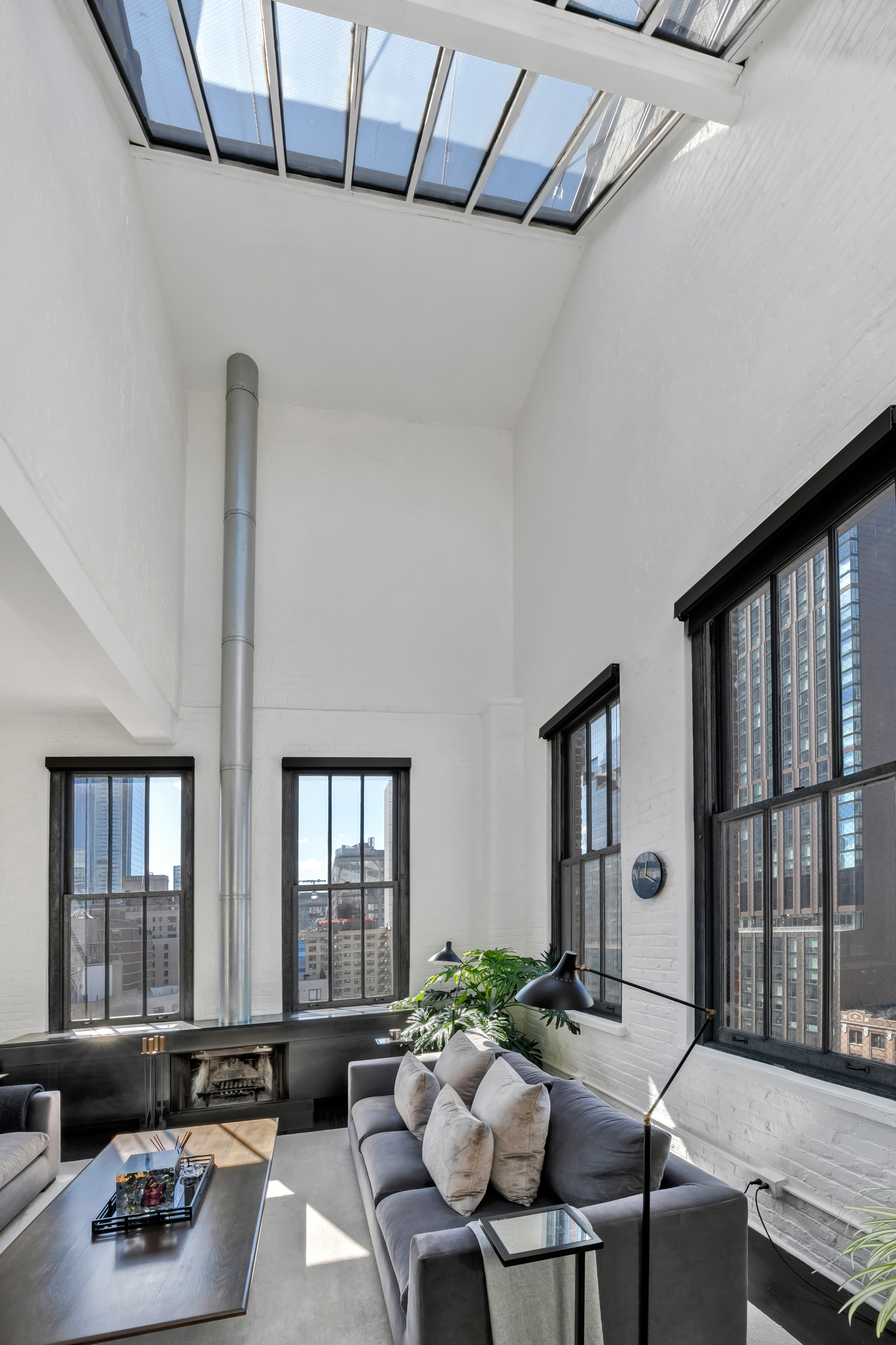 448 West 37th Street, Unit 11G/12G Manhattan, NY 10018 - Photo 2 of 17 a living room with furniture and a window