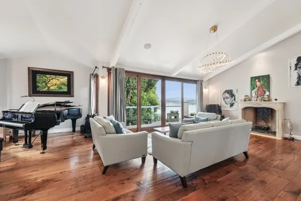 a living room with fireplace furniture and a large window