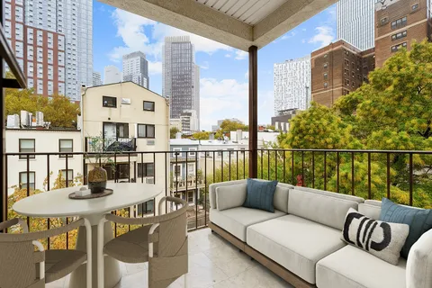 a balcony with table and chairs