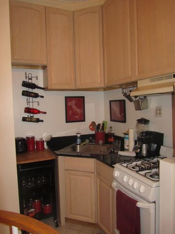 126 East 83rd Street, Unit A2 Manhattan, NY 10028 - Photo 2 of 5 a kitchen with stainless steel appliances granite countertop a stove a microwave and cabinets