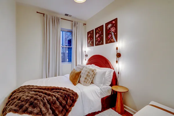 a bedroom with a bed and a painting on the wall