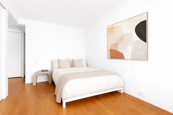 a bedroom with a bed and a painting on the wall