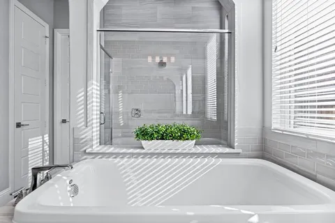 a white bath tub sitting in a bathroom next to a window