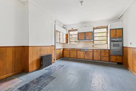 an empty room with windows and fireplace