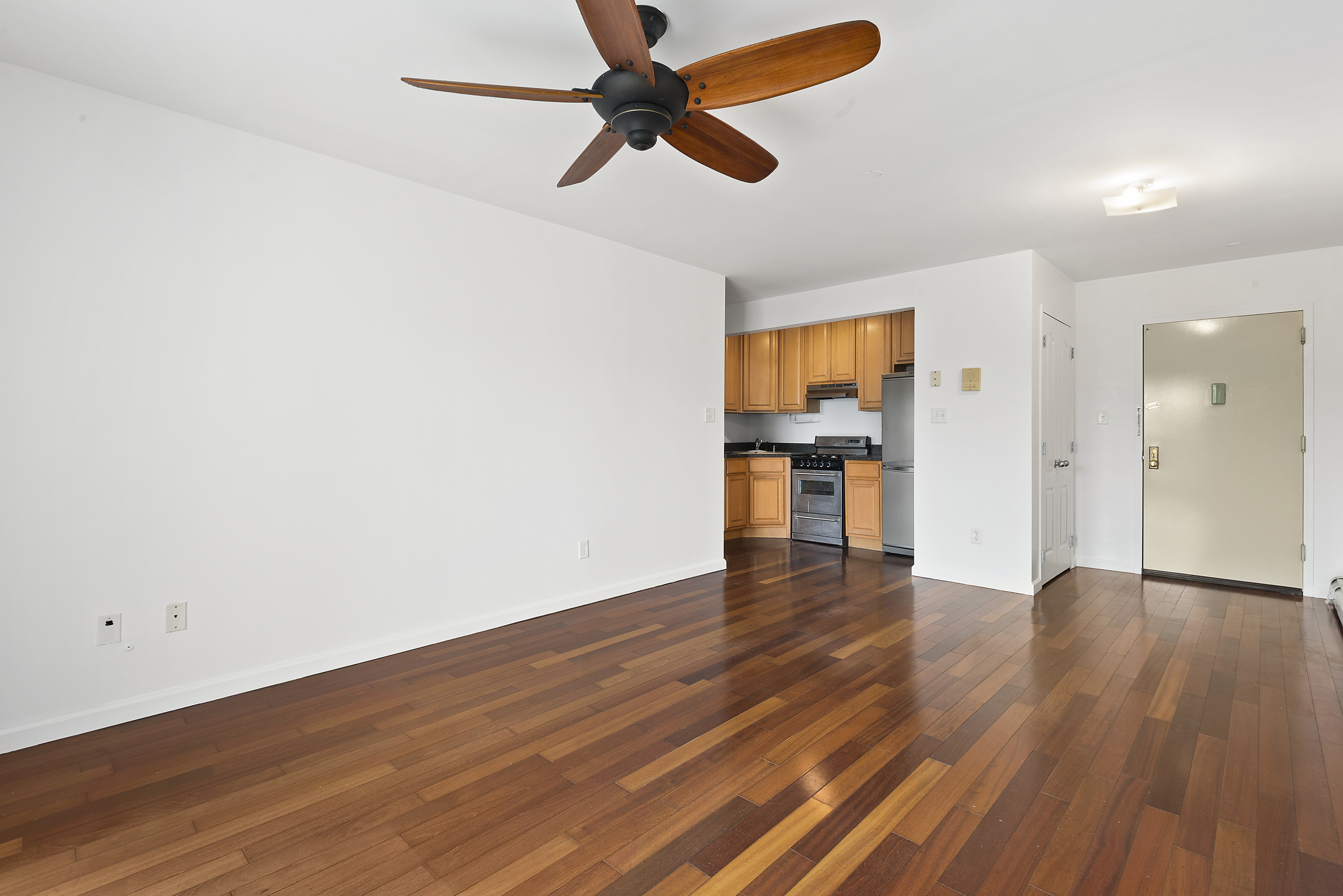 122 Boerum Street, Unit 4R Brooklyn, NY 11206 - Photo 4 of 9 a view of empty room with wooden floor and fan