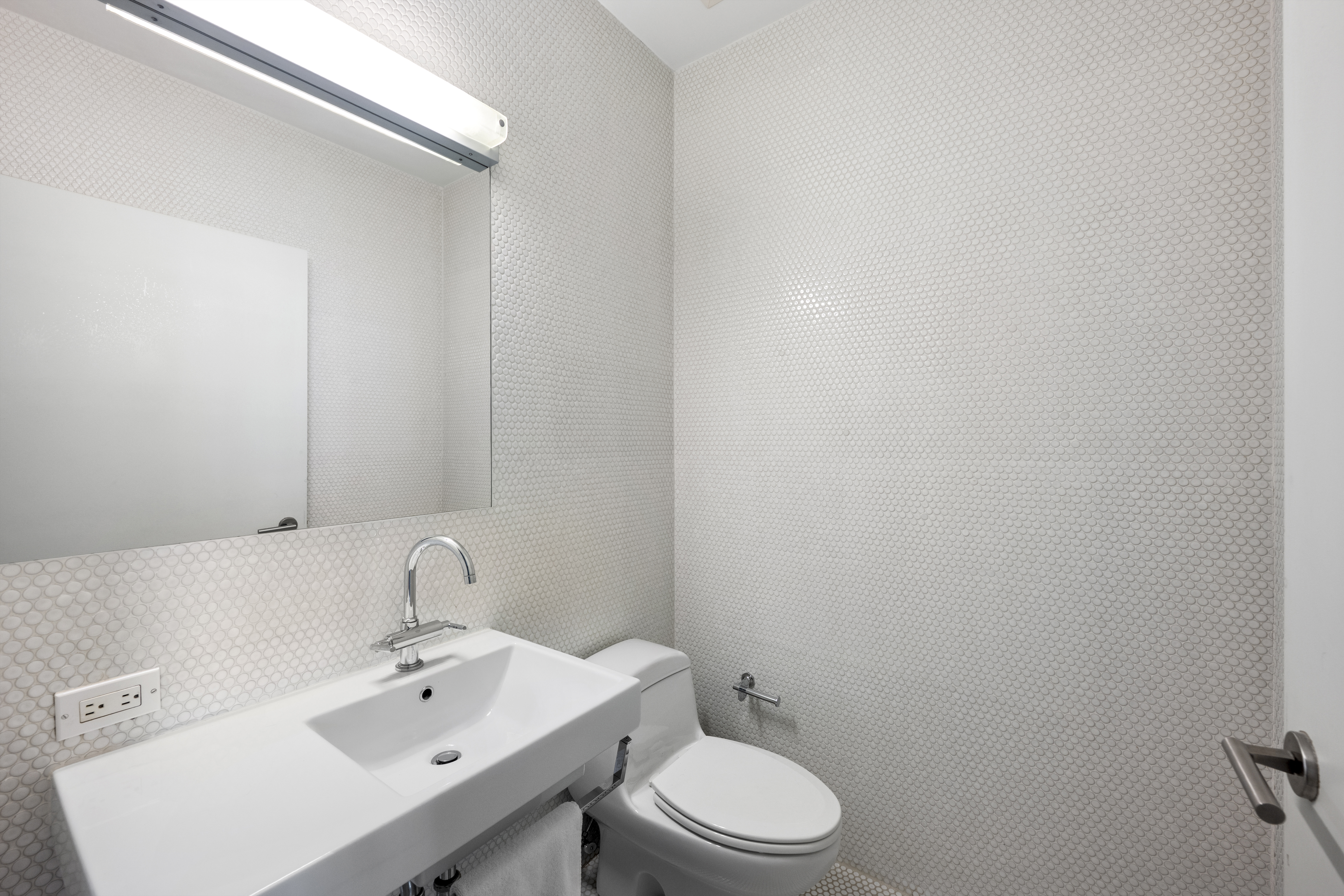 475 Greenwich Street, Unit 5B Manhattan, NY 10013 - Photo 11 of 16 a bathroom with a sink a toilet and mirror