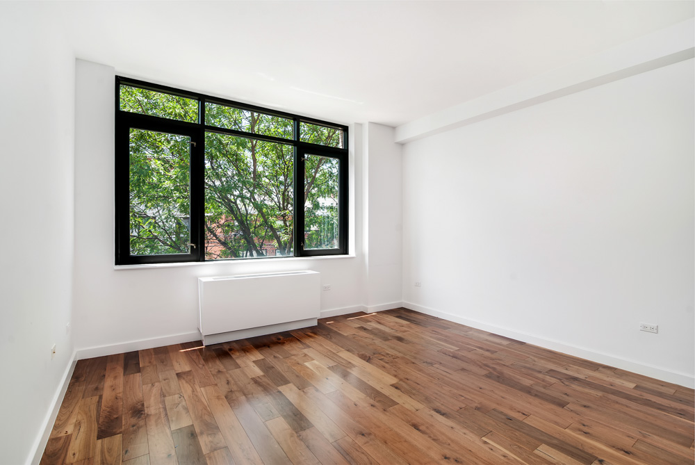 125 North 5th Street, Unit 3D Brooklyn, NY 11249 - Photo 4 of 10 an empty room with wooden floor and windows