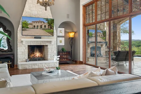 a living room with furniture a fireplace and a floor to ceiling window