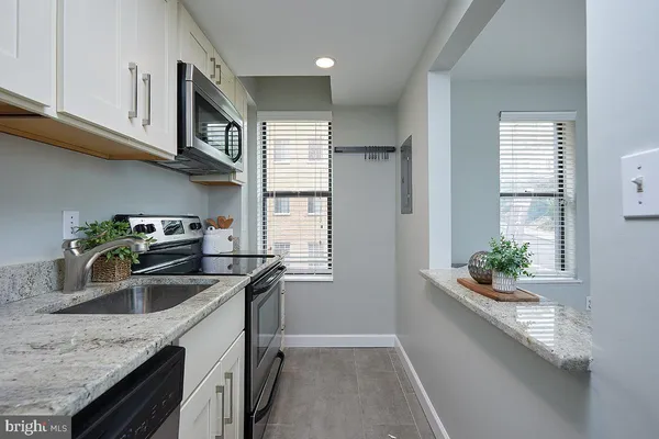 a kitchen with stainless steel appliances granite countertop a sink a stove and a granite counter tops