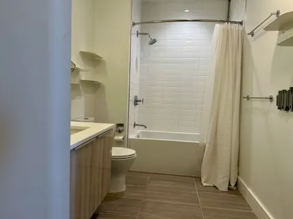 a bathroom with a granite countertop shower toilet and bathtub