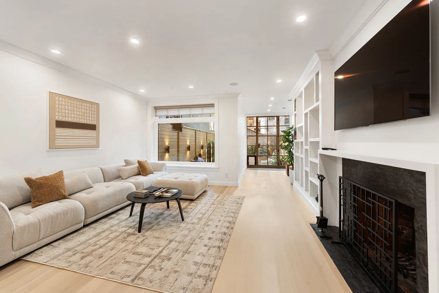 a living room with furniture a flat screen tv and a fireplace
