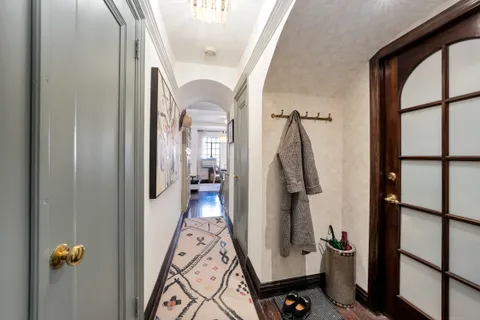 a view of a hallway with wooden floor and staircase