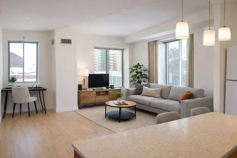 a living room with furniture a large window and a flat screen tv