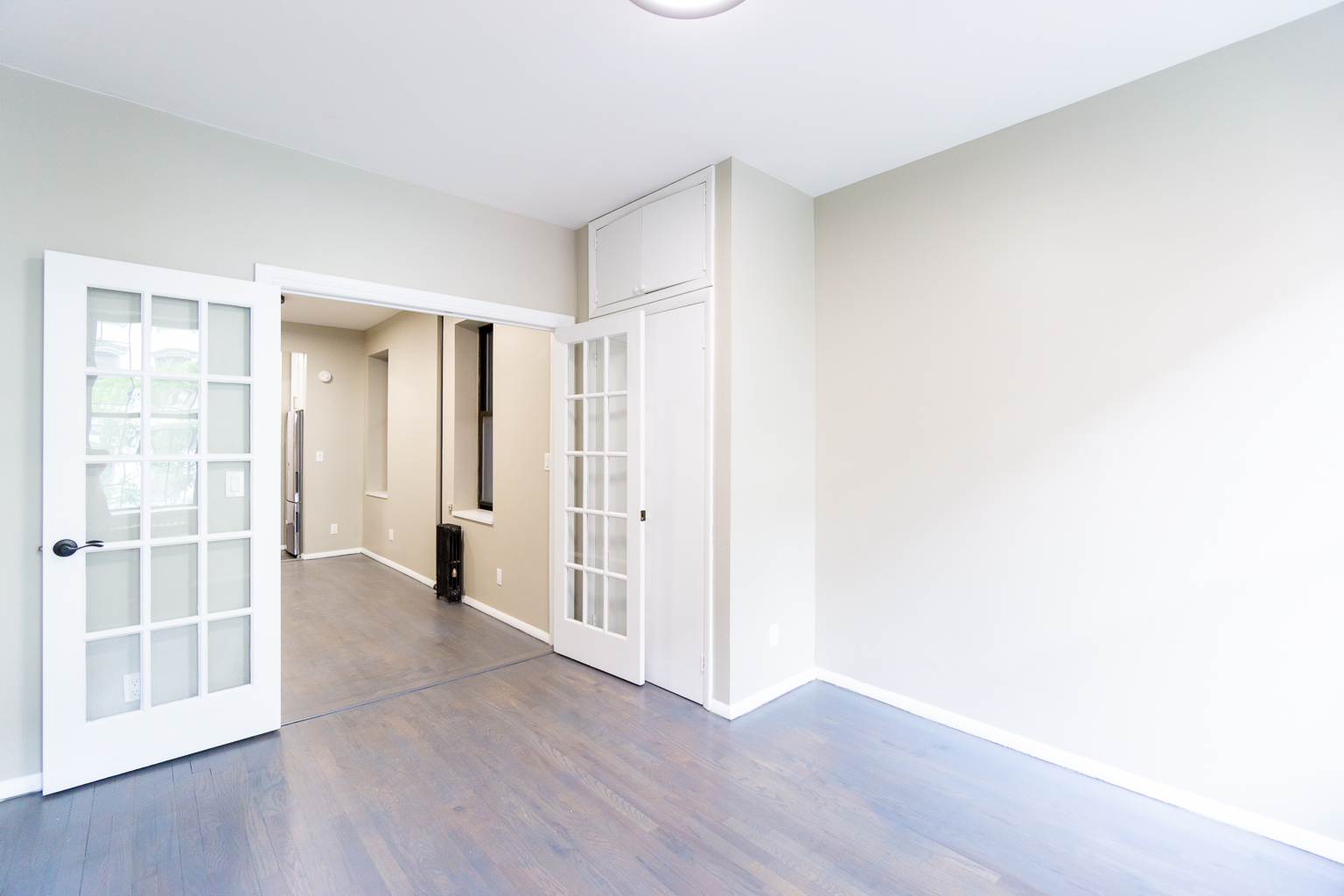 338 East 5th Street, Unit 5 Manhattan, NY 10003 - Photo 2 of 11 a view of an empty room with wooden floor and a window