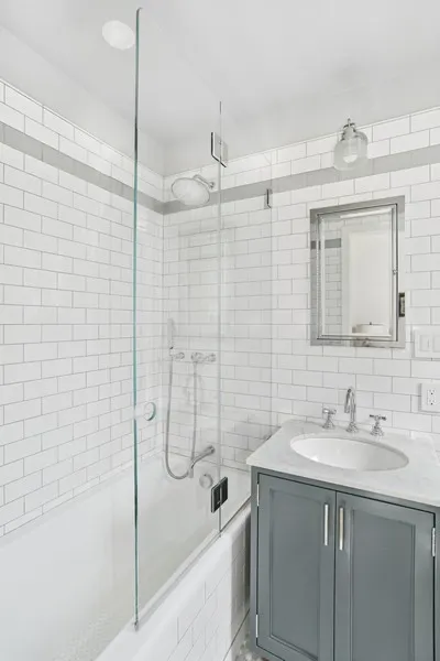 a bathroom with a shower sink vanity and mirror