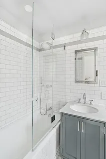 a bathroom with a shower sink vanity and mirror
