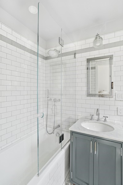 350 East 57th Street, Unit 14B Manhattan, NY 10022 - Photo 12 of 14 a bathroom with a shower sink vanity and mirror