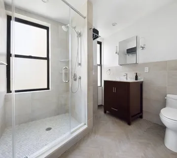 a bathroom with a double vanity sink toilet and shower