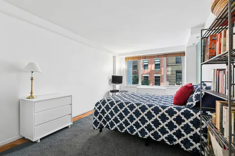 a bed sitting in a bedroom next to a large window