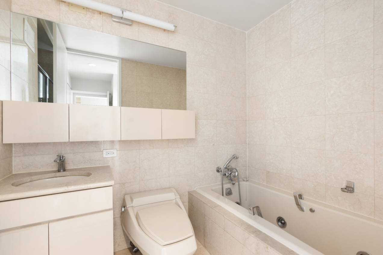160 West 66th Street, Unit 20F Manhattan, NY 10023 - Photo 6 of 7 a bathroom with a sink a toilet and vanity