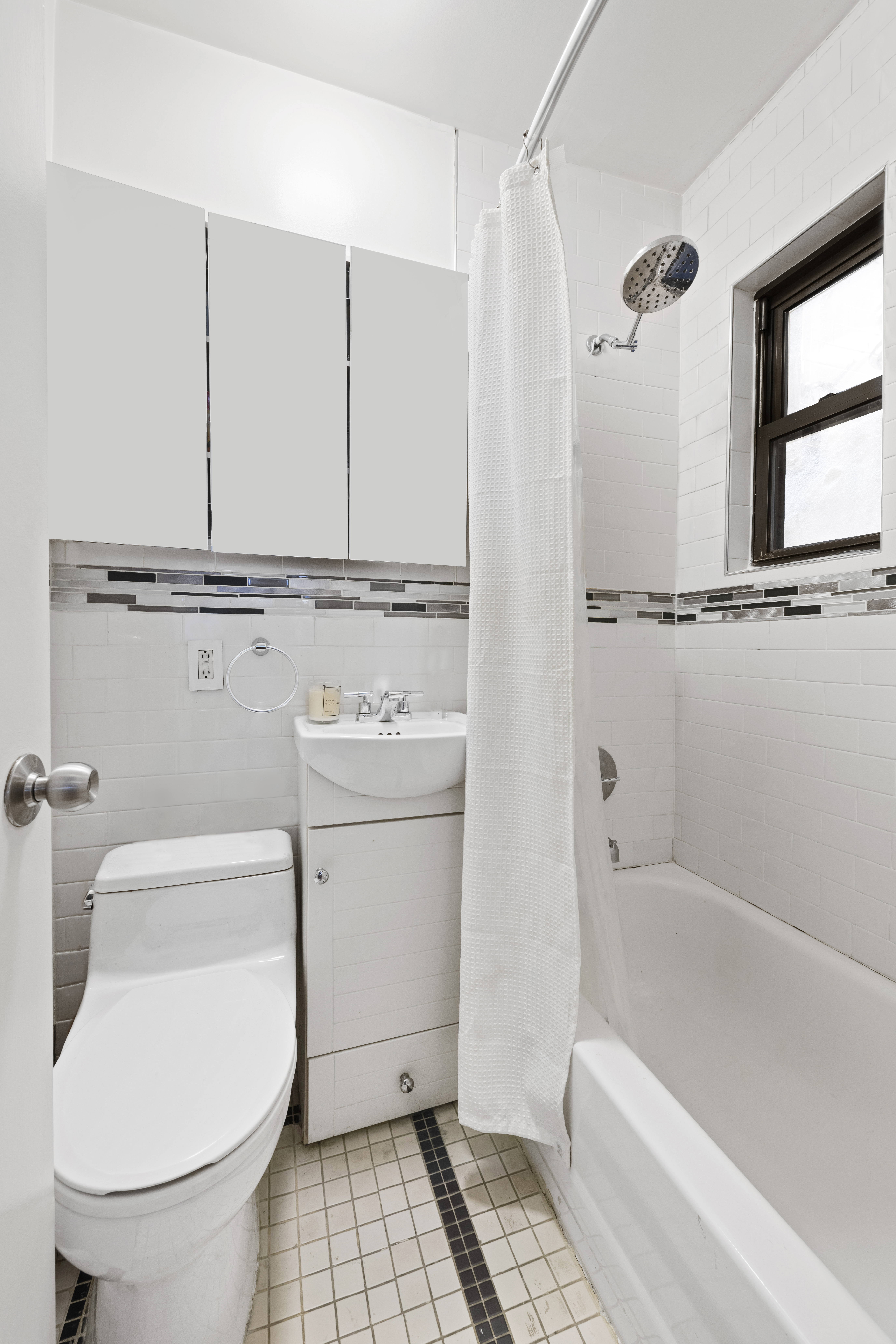 237 East 88th Street, Unit 303 Manhattan, NY 10128 - Photo 4 of 4 a bathroom with a toilet a sink and bathtub