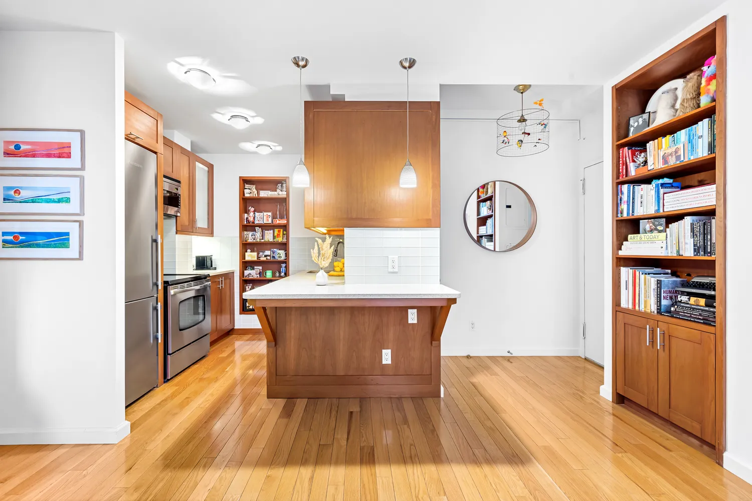 a living room with stainless steel appliances furniture a large window and a bookshelf