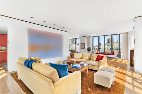 a bedroom with a bed and large windows