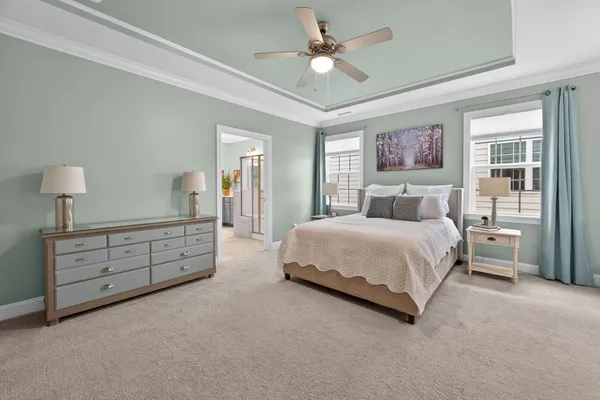 a bedroom with a large bed and a chandelier