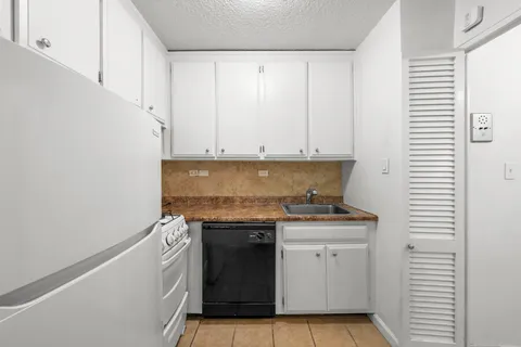 a kitchen with granite countertop cabinets stainless steel appliances and a sink