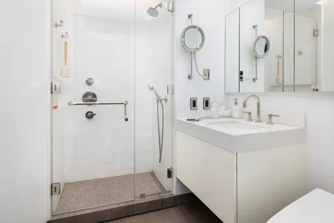 a bathroom with a sink a mirror a shower and vanity