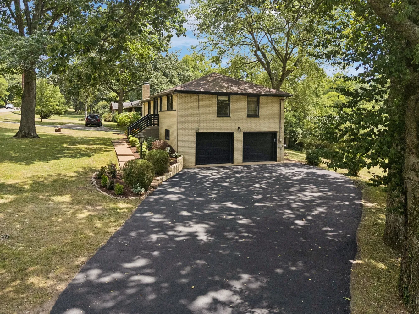 a front view of a house with a large tree and yard