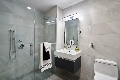 a bathroom with a double vanity sink toilet and shower