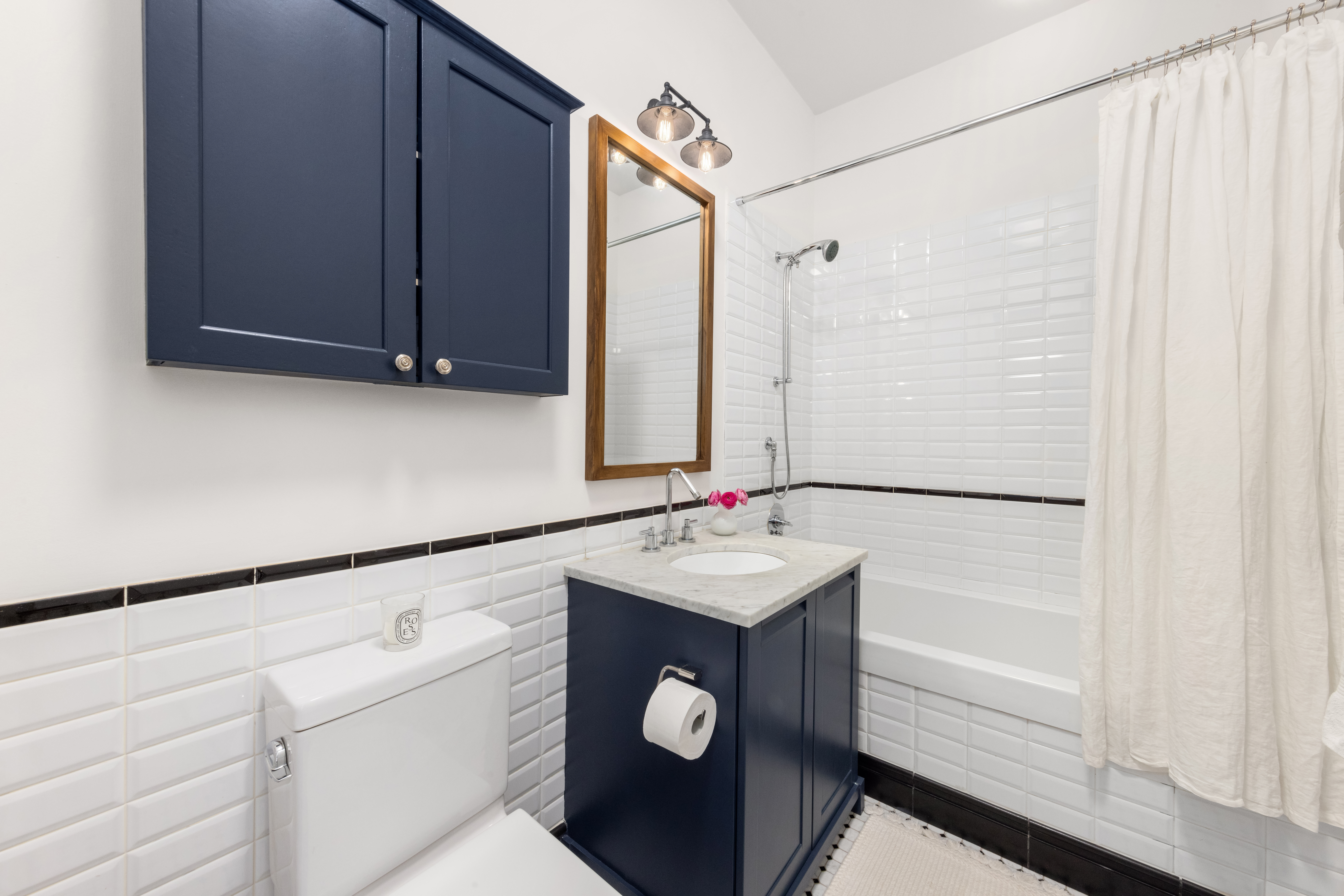 655 6th Avenue, Unit 5H Manhattan, NY 10010 - Photo 10 of 15 a bathroom with a sink and a mirror