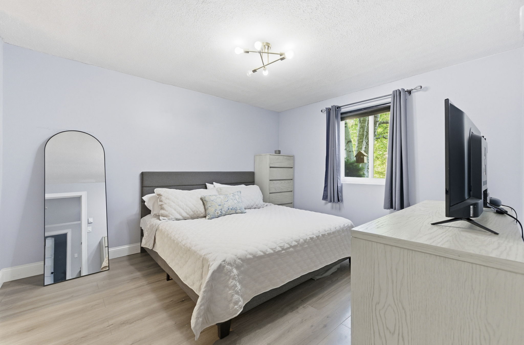 61 Wright Street, Unit 102 Stoneham, MA 02180 - Photo 14 of 26 a bedroom with a bed and a flat screen tv
