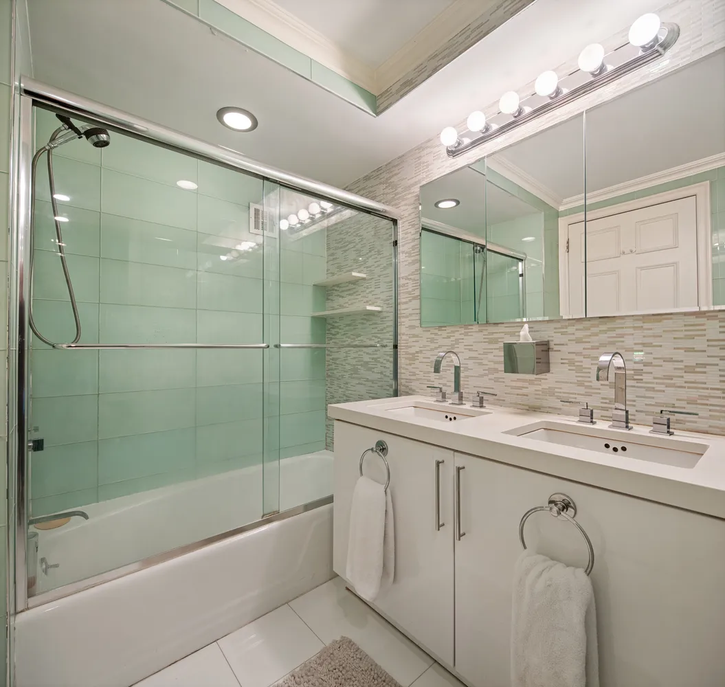a bathroom with a granite countertop sink mirror and a bathtub