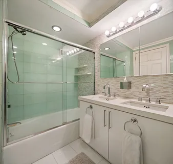 a bathroom with a granite countertop sink mirror and a bathtub