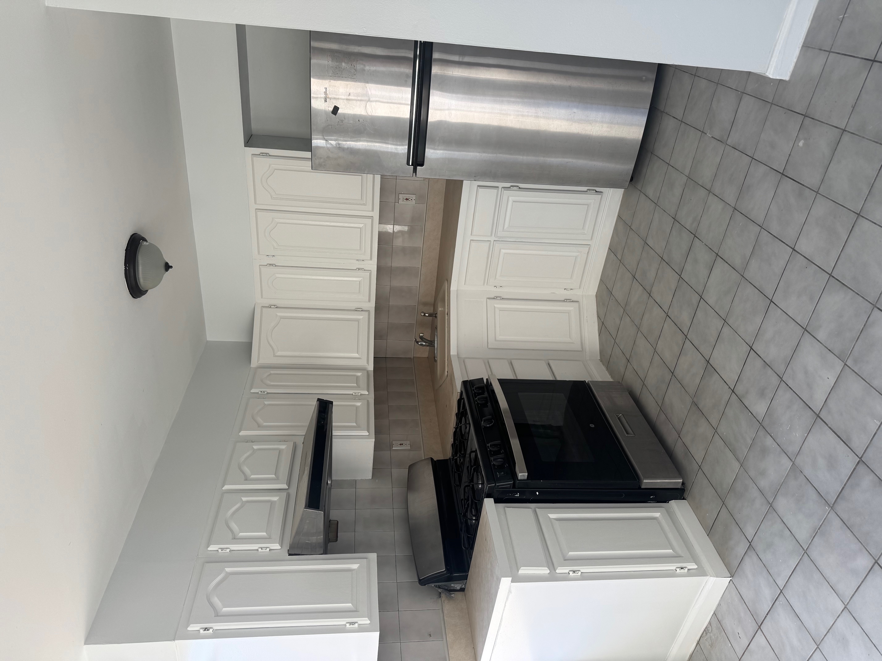 89-16 102nd Road, Unit 2 Queens, NY 11416 - Photo 3 of 13 a kitchen with white cabinets and refrigerator