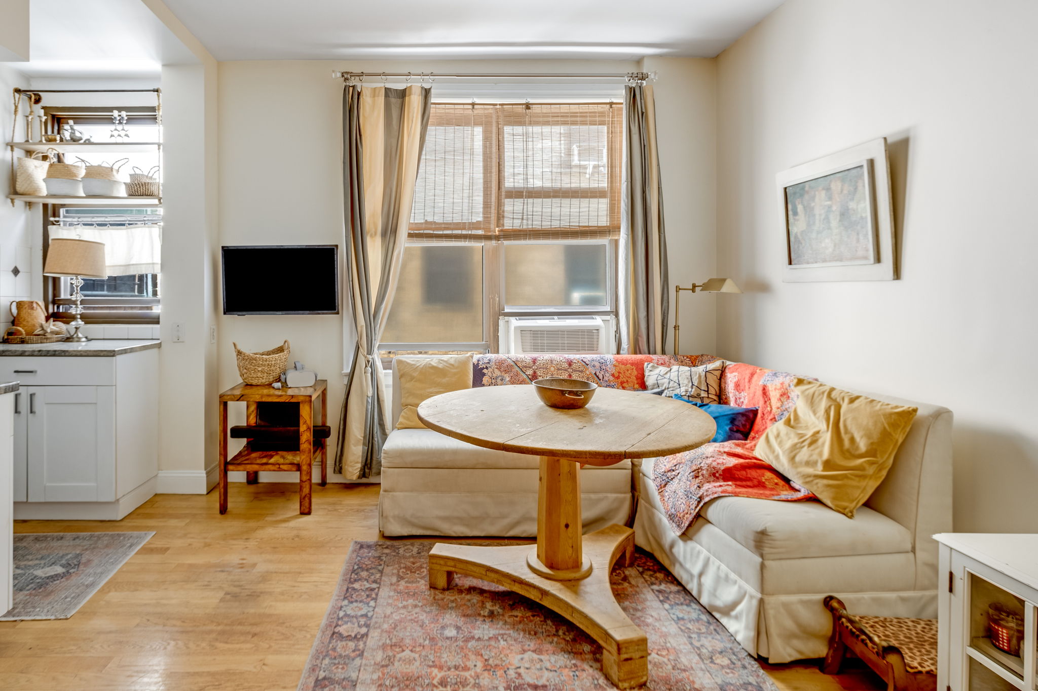 345 East 77th Street, Unit 3C Manhattan, NY 10075 - Photo 3 of 8 a living room with furniture a flat screen tv and a window
