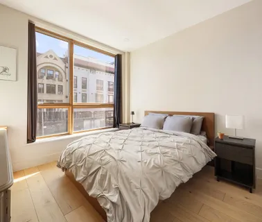 a bedroom with a bed and a large window