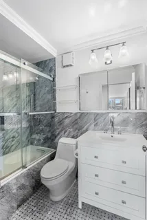 a bathroom with a sink a toilet and shower