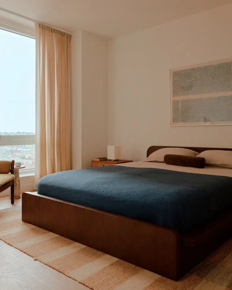 a bed sitting in a bedroom next to a window