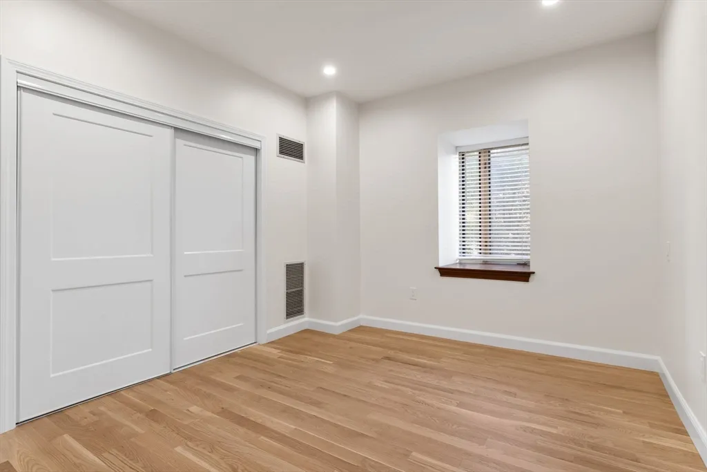 a view of empty room with wooden floor