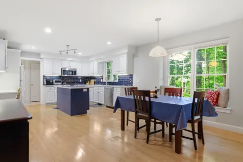 a view of a dining room and livingroom with furniture window and wooden floor