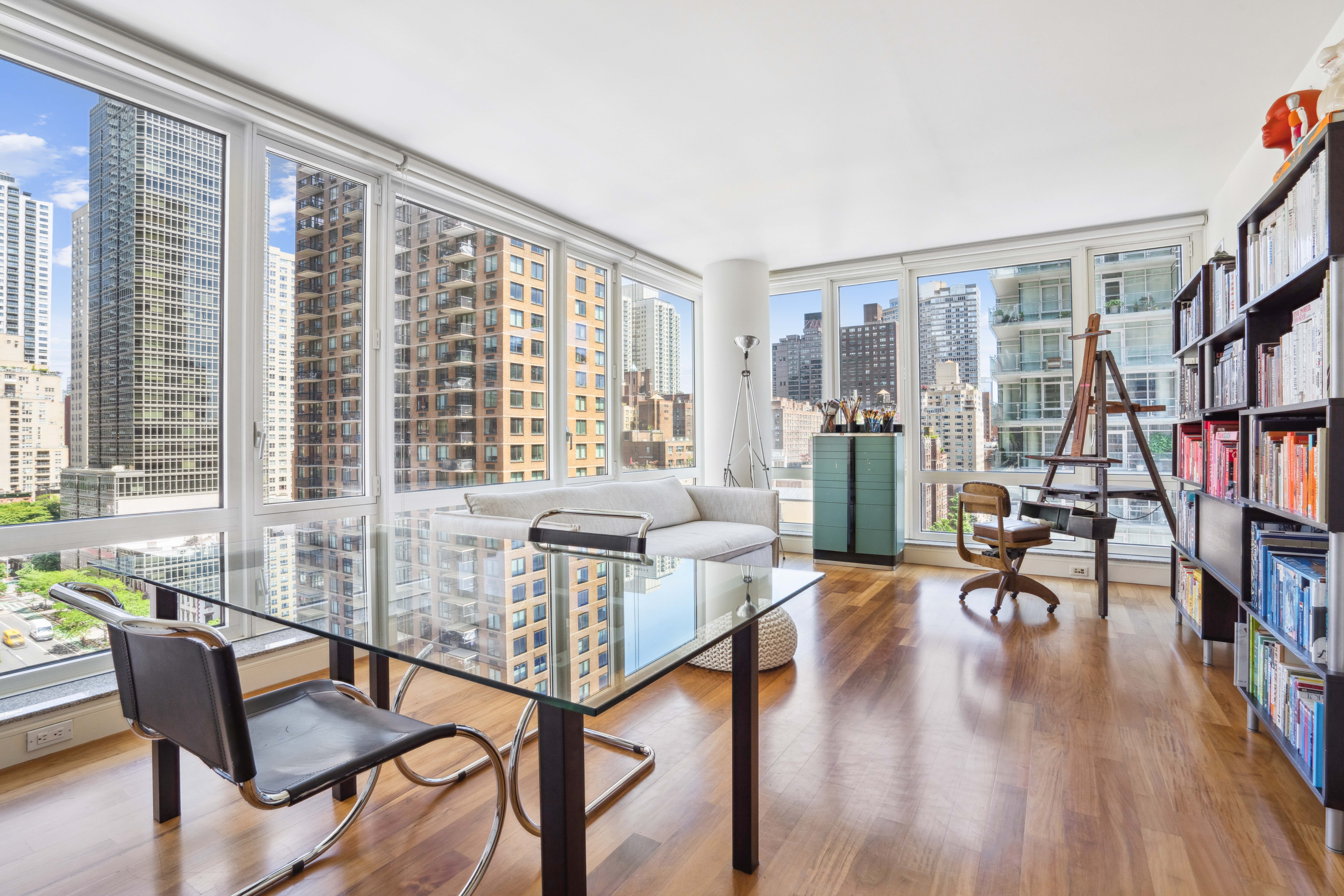 250 East 53rd Street, Unit 1402 Manhattan, NY 10022 - Photo 2 of 13 a living room with furniture and a book shelf