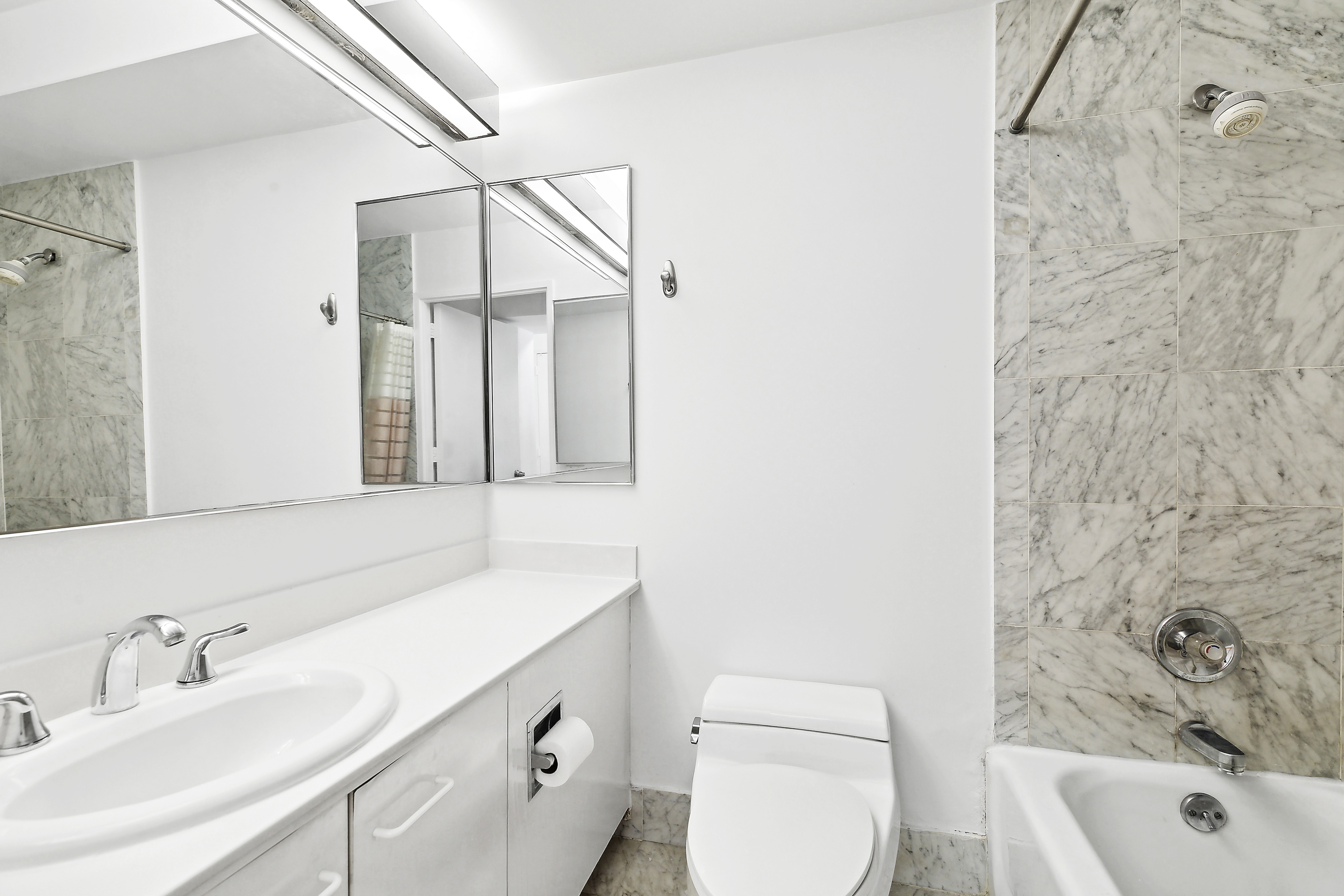 330 East 38th Street, Unit 38G Manhattan, NY 10016 - Photo 5 of 7 a bathroom with a sink a toilet and shower