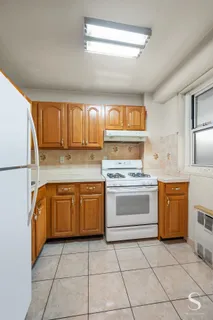 a kitchen with granite countertop a stove top oven sink and cabinets
