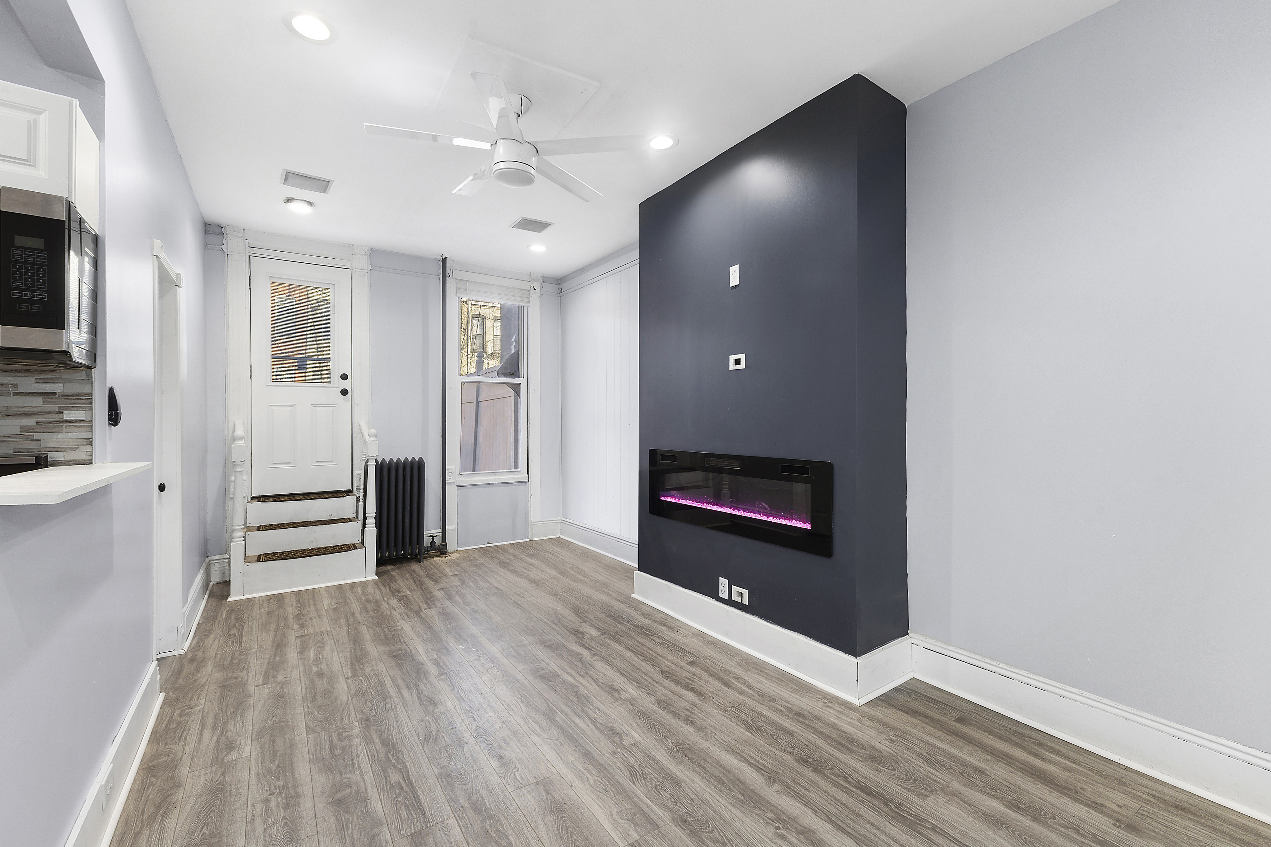 693 MacDonough Street, Unit 2A Brooklyn, NY 11233 - Photo 5 of 11 wooden floor in an empty room with a fireplace