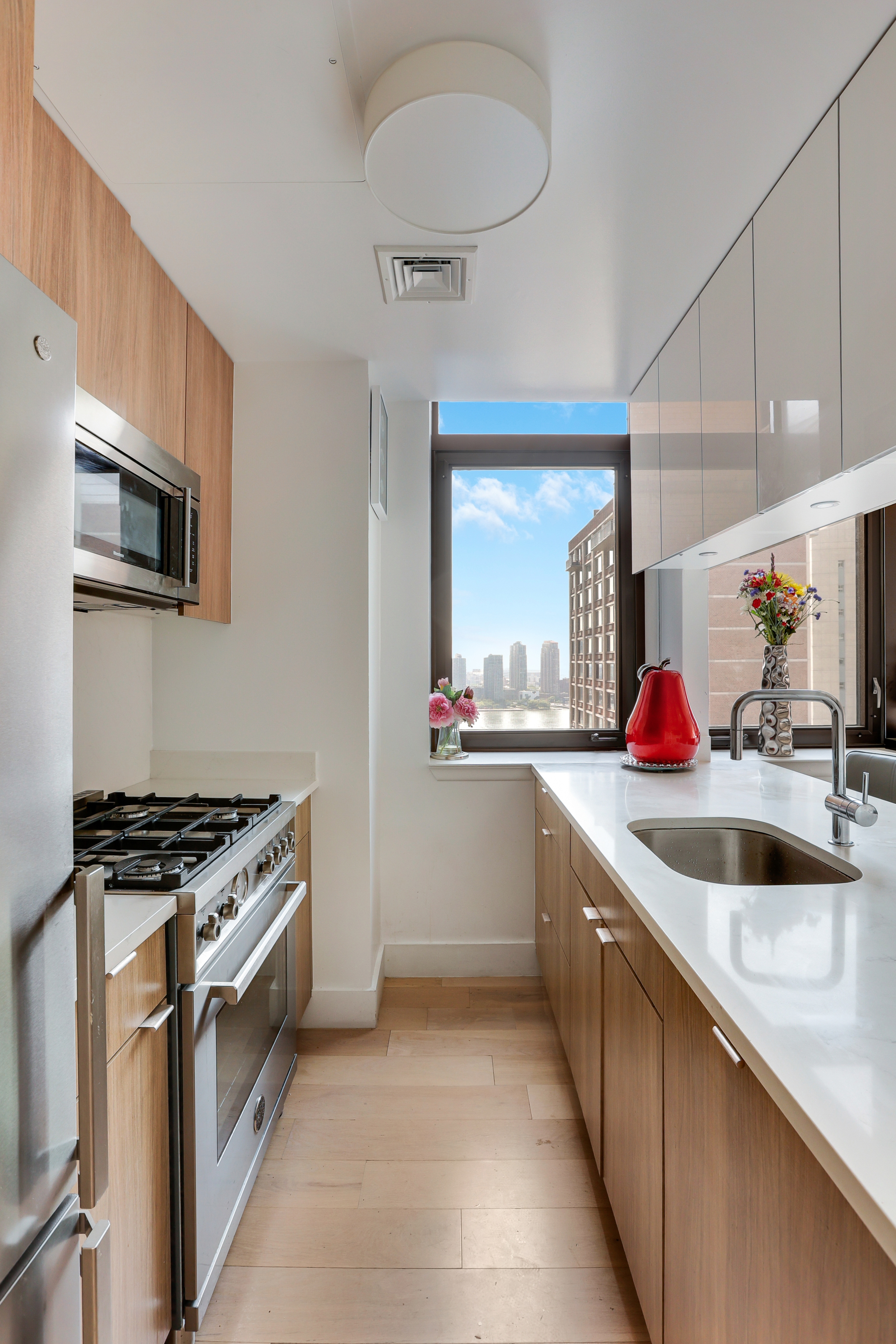 310 East 46th Street, Unit 20H Manhattan, NY 10017 - Photo 5 of 9 a kitchen with stainless steel appliances granite countertop a sink and a stove