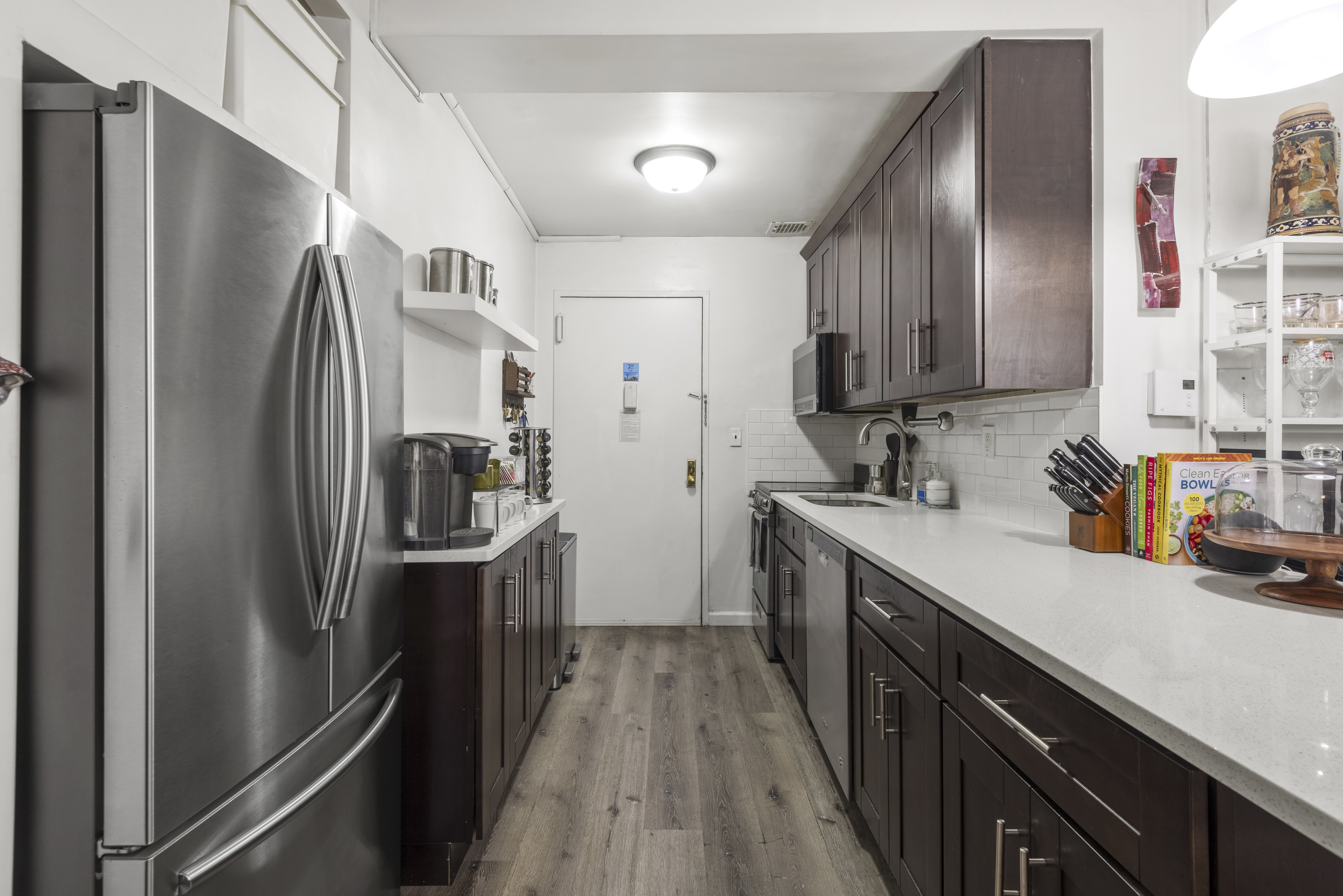 45 Overlook Terrace, Unit 7J Manhattan, NY 10033 - Photo 2 of 11 a kitchen with stainless steel appliances a refrigerator sink and wooden cabinets